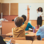 Student raising their arm to volunteer